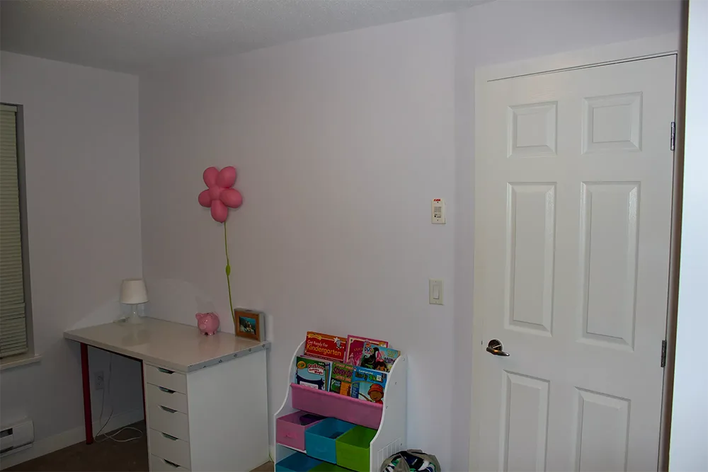White bedroom with a desk, bookshelf, and door; interior painting example AZ Painting Ltd.