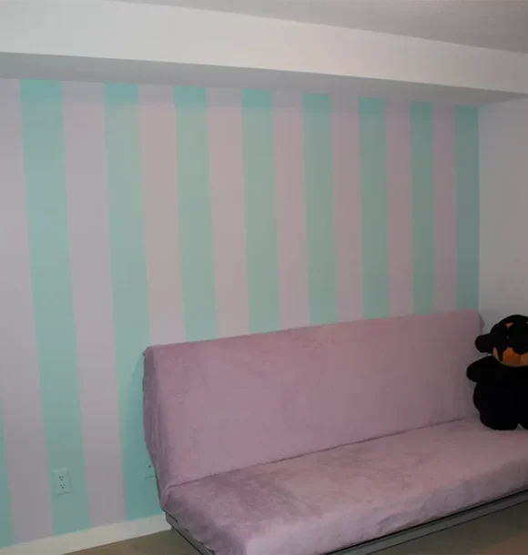 Pink futon in a bedroom with pastel striped walls AZ Painting Ltd.