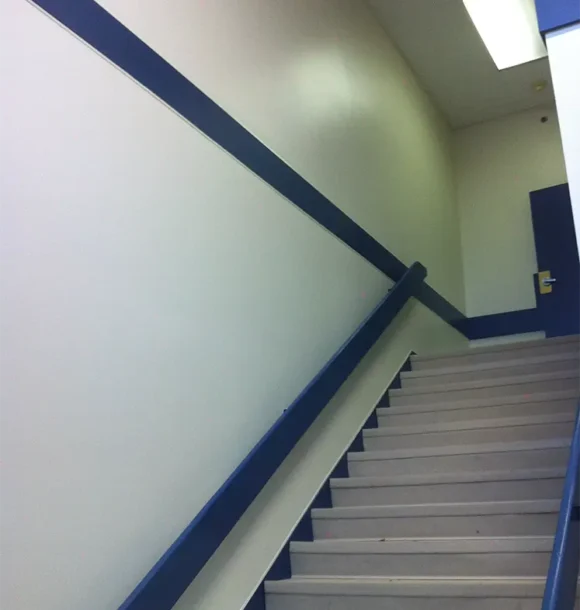 Interior painting transformation of office stairwell with blue trim AZ Painting Ltd.